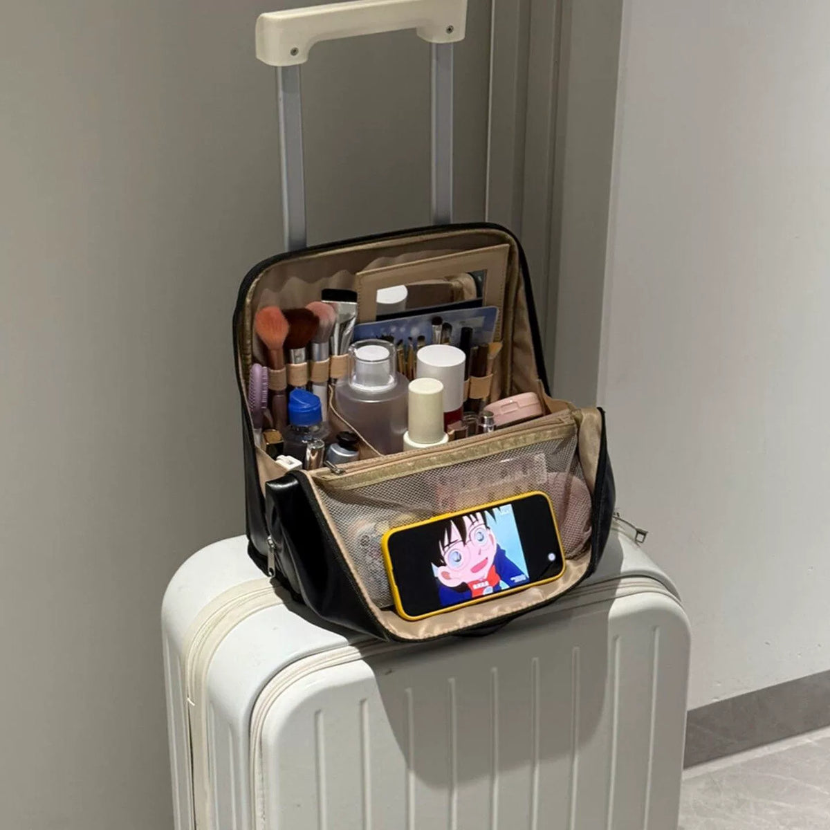 Black makeup organizer displayed open on luggage