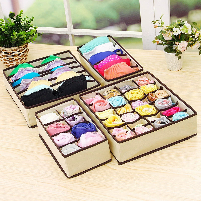 Four off-white divided fabric organizers filled with everyday clothing